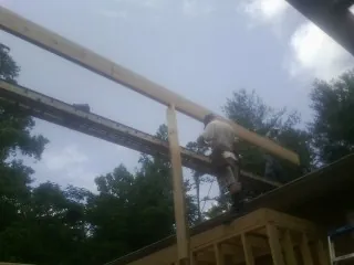 Carpenter setting a ridge beam over a new addition frame — Ice Dam Removal by Roofing Brothers in Great Cacapon